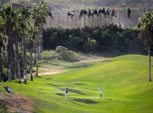 Imagen 5. Inmigrantes frente al campo de golf situado al lado de la alambrada que separa Melilla, ciudad autónoma, de Marruecos. © José Palazón / Prodein