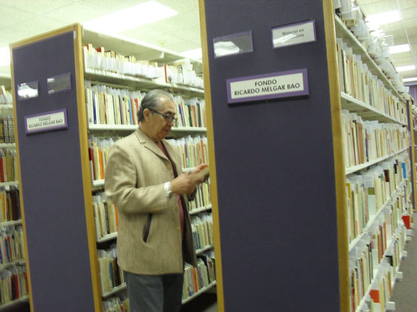 Ricardo Melgar Bao en medio de algunos estantes del Fondo Ricardo Melgar Bao, Biblioteca central, UACJ, México, 2015